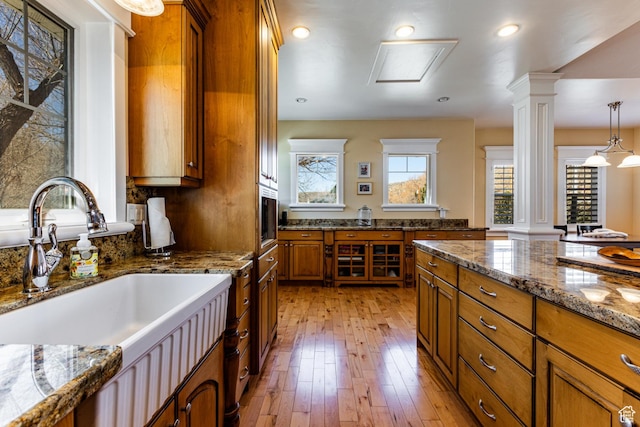 2503 W State Road 32, Peoa, UT 84061 - kitchen featuring light wood finished floors, decorative columns, brown cabinetry, and a sink