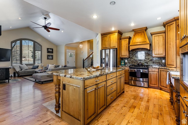 2503 W State Road 32, Peoa, UT 84061 - kitchen featuring ceiling fan, premium range hood, appliances with stainless steel finishes, light stone counters, and brown cabinetry