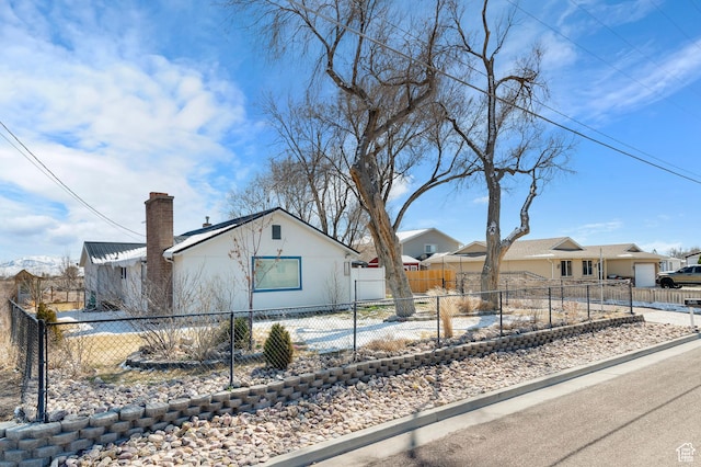 view of property exterior with a chimney and a fenced front yard