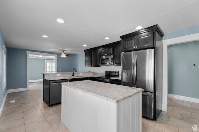 kitchen with a sink, appliances with stainless steel finishes, a peninsula, a center island, and ceiling fan