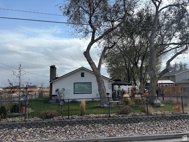 view of front facade featuring a chimney and a fenced front yard