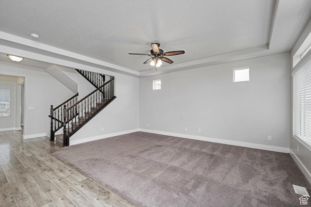 1146 W 1875 S, Syracuse, UT 84075 - unfurnished living room featuring a ceiling fan, wood finished floors, baseboards, a tray ceiling, and stairs