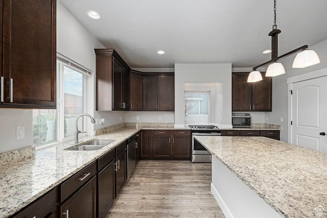1146 W 1875 S, Syracuse, UT 84075 - kitchen with dark brown cabinetry, light stone counters, a sink, stainless steel appliances, and light wood-type flooring