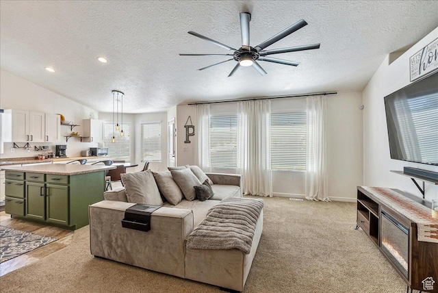 6403 W Muzzle Loader Dr, Herriman, UT 84096 - living area featuring light colored carpet, a ceiling fan, a textured ceiling, and recessed lighting