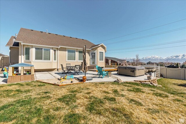6403 W Muzzle Loader Dr, Herriman, UT 84096 - back of property featuring a patio area, fence, a hot tub, a mountain view, and stucco siding