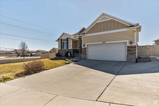 6403 W Muzzle Loader Dr, Herriman, UT 84096 - craftsman-style home with fence, an attached garage, board and batten siding, driveway, and stone siding