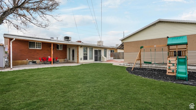 4535 S Ridgeline Dr, Ogden, UT 84405 - back of house with fence, a playground, a patio, brick siding, and a yard