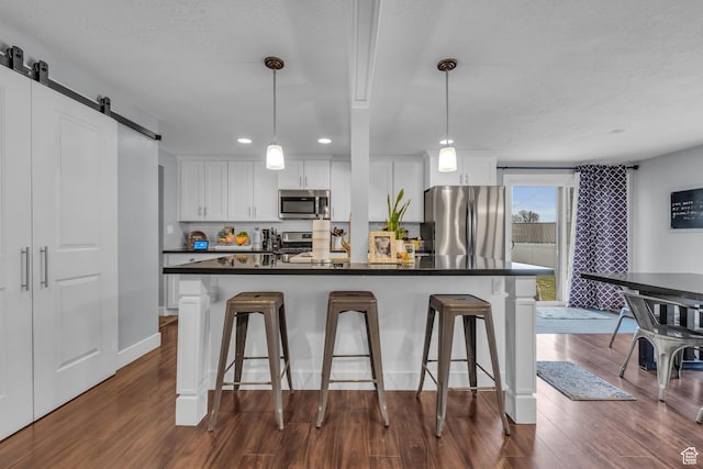 175 E Millerberg Dr S, Sandy, UT 84070 - kitchen featuring a kitchen breakfast bar, white cabinetry, dark countertops, and appliances with stainless steel finishes