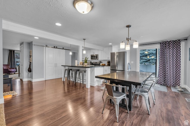 175 E Millerberg Dr S, Sandy, UT 84070 - dining area featuring a textured ceiling, baseboards, recessed lighting, a barn door, and dark wood-style floors