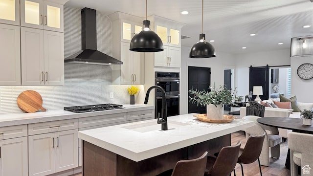 813 S 1260 W Unit 111, Heber City, UT 84032 - kitchen featuring a kitchen breakfast bar, double oven, a sink, stainless steel gas stovetop, and wall chimney range hood