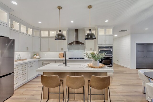 813 S 1260 W Unit 111, Heber City, UT 84032 - kitchen featuring light countertops, visible vents, light wood finished floors, stainless steel appliances, and wall chimney range hood
