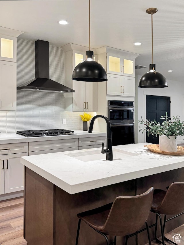 813 S 1260 W Unit 111, Heber City, UT 84032 - kitchen featuring decorative backsplash, stainless steel gas cooktop, wall chimney exhaust hood, a sink, and multiple ovens