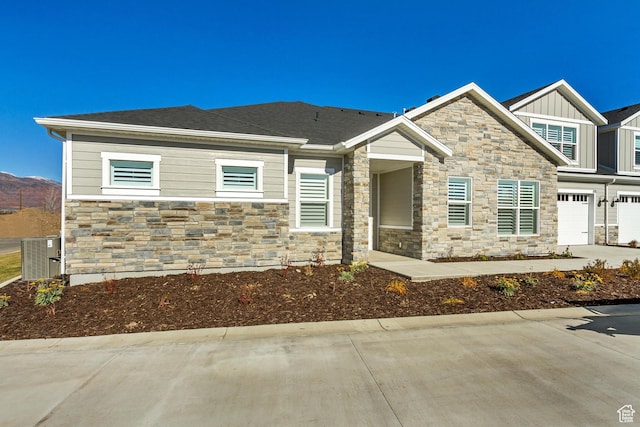 813 S 1260 W Unit 111, Heber City, UT 84032 - view of front of property featuring stone siding, central AC unit, an attached garage, concrete driveway, and board and batten siding