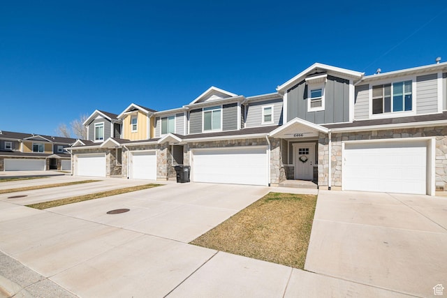 multi unit property featuring stone siding, an attached garage, board and batten siding, and a residential view