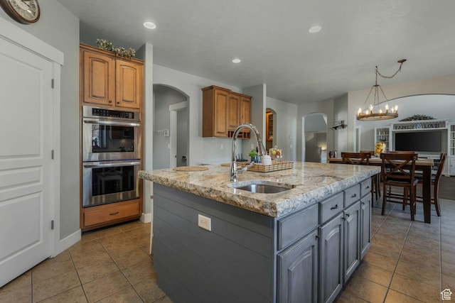 11773 S Twin Pines Ct, Draper, UT 84020 - kitchen with light tile patterned flooring, a sink, double oven, light stone countertops, and arched walkways