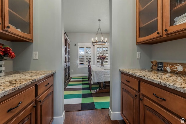 11773 S Twin Pines Ct, Draper, UT 84020 - kitchen with dark wood-style flooring, light stone countertops, brown cabinetry, and a chandelier