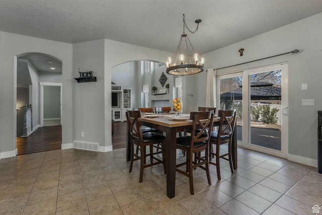 11773 S Twin Pines Ct, Draper, UT 84020 - tiled dining area featuring baseboards, visible vents, arched walkways, and a chandelier