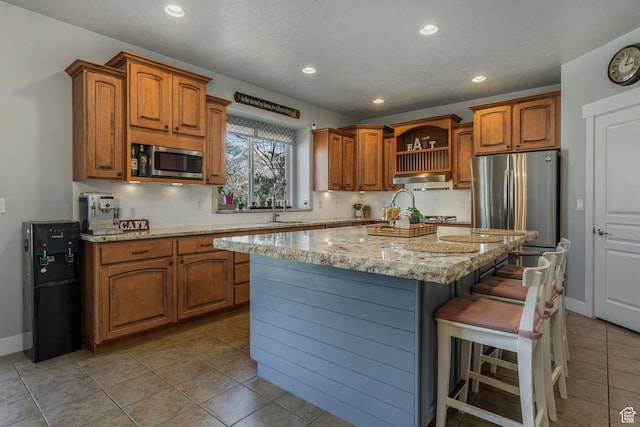 11773 S Twin Pines Ct, Draper, UT 84020 - kitchen with brown cabinets, decorative backsplash, a kitchen bar, and stainless steel appliances