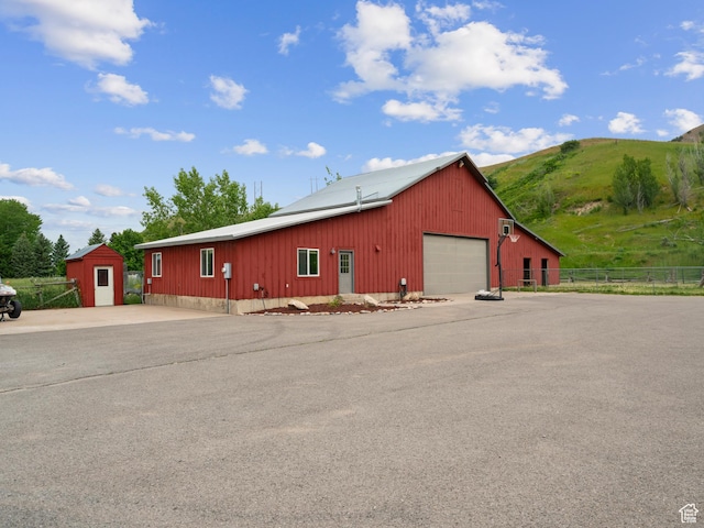 exterior space featuring a mountain view, fence, and an outdoor structure