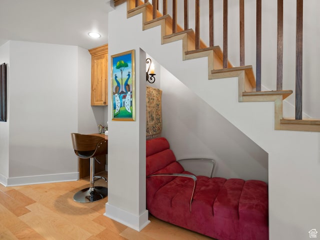 stairs with recessed lighting, wood finished floors, and baseboards