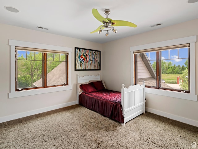 bedroom with visible vents, light colored carpet, and baseboards