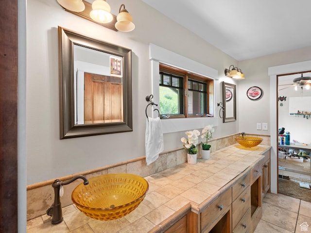 bathroom featuring tile patterned floors, a sink, a ceiling fan, and double vanity