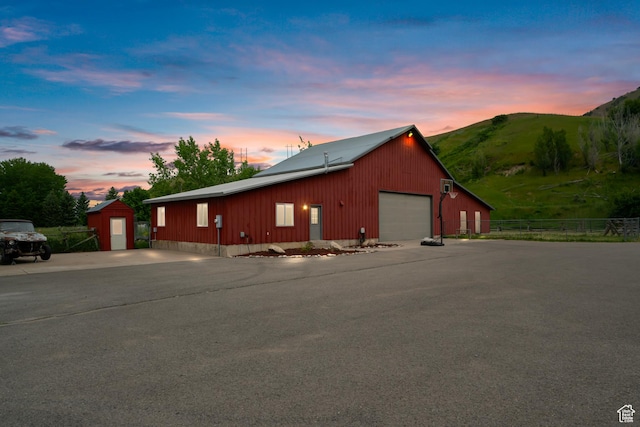 exterior space with an outdoor structure, a shed, a mountain view, fence, and a garage