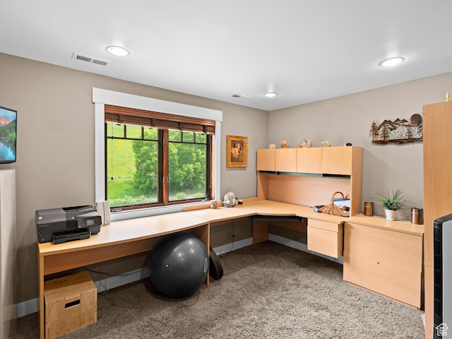 carpeted office with built in desk, recessed lighting, and visible vents