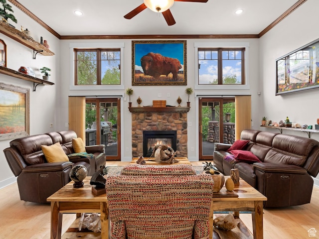 living area featuring crown molding, a towering ceiling, and a stone fireplace