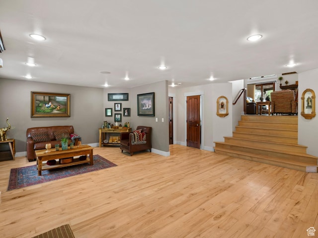living room featuring baseboards, recessed lighting, wood finished floors, and stairs