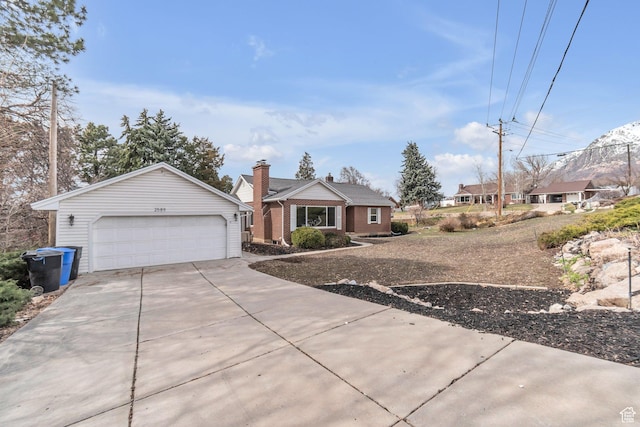 ranch-style home with driveway, a garage, and a chimney