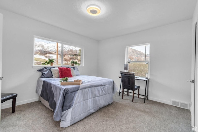 carpeted bedroom featuring baseboards and visible vents