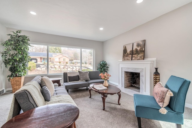 living room featuring baseboards, a fireplace, recessed lighting, and carpet