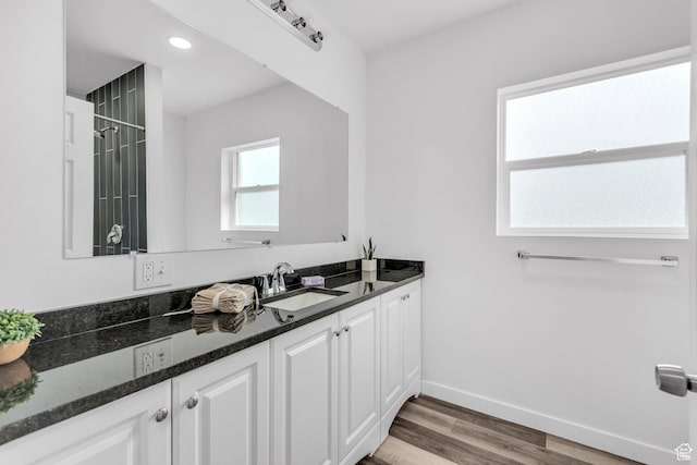 full bath featuring a shower, vanity, recessed lighting, baseboards, and wood finished floors