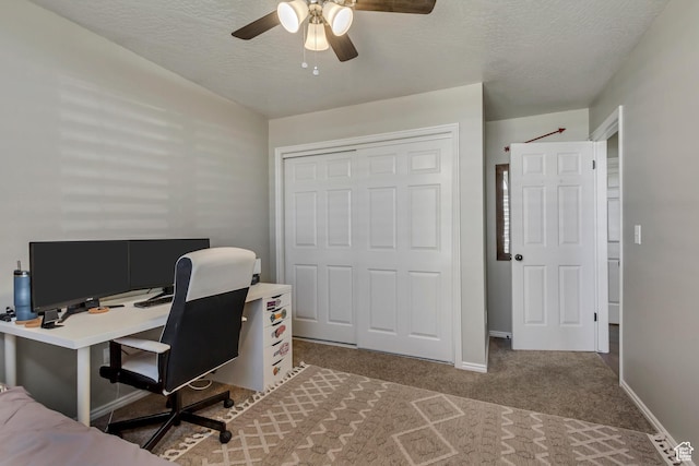 carpeted office with baseboards, a textured ceiling, and ceiling fan