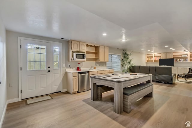 rec room with baseboards, a healthy amount of sunlight, and light wood-style floors