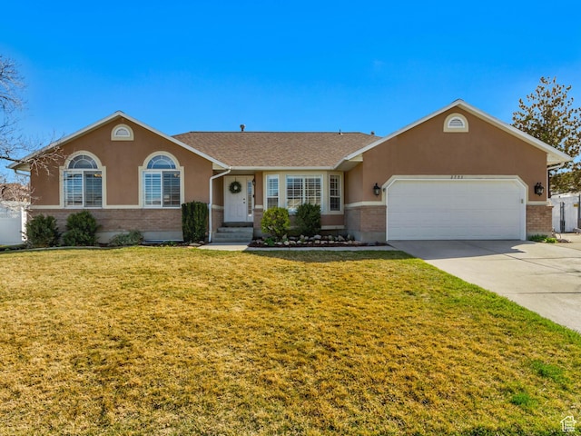 single story home featuring a front yard, concrete driveway, and stucco siding