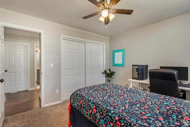 carpeted bedroom with a closet, a textured ceiling, baseboards, and a ceiling fan