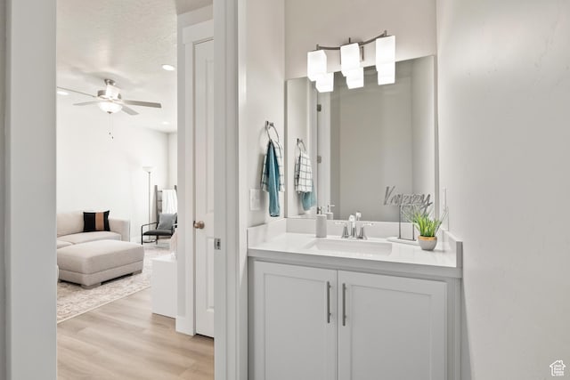 bathroom featuring vanity, a textured ceiling, connected bathroom, ceiling fan, and wood finished floors