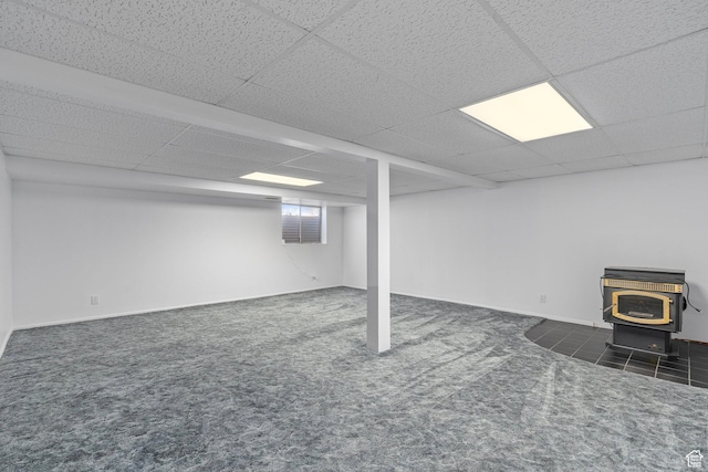 252 W Durfee St, Grantsville, UT 84029 - below grade area featuring a wood stove, carpet, a paneled ceiling, and baseboards