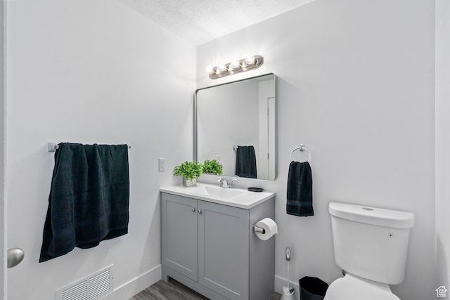 252 W Durfee St, Grantsville, UT 84029 - half bathroom with toilet, vanity, baseboards, wood finished floors, and a textured ceiling