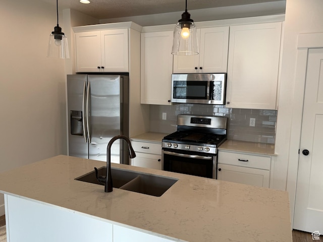 kitchen featuring white cabinets, a sink, tasteful backsplash, and appliances with stainless steel finishes