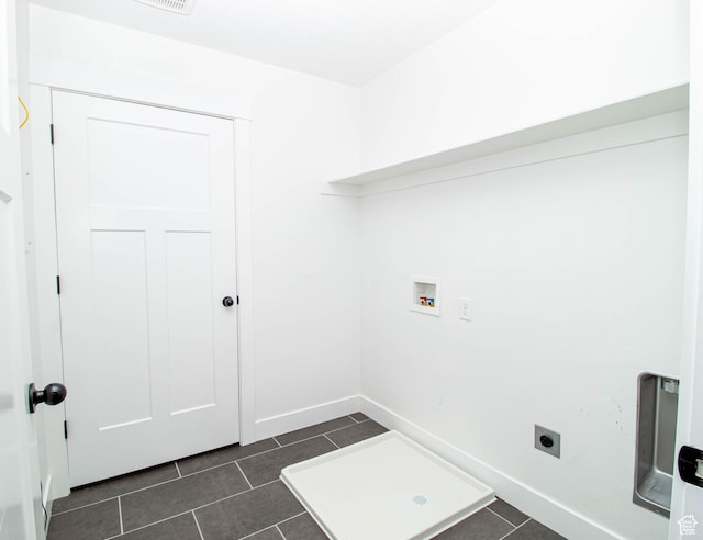 laundry room featuring hookup for an electric dryer, hookup for a washing machine, dark tile patterned flooring, baseboards, and laundry area