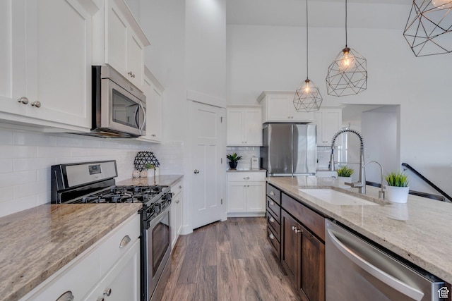 9844 N Faust Station Dr W, Eagle Mountain, UT 84005 - kitchen with white cabinetry, dark wood finished floors, hanging light fixtures, a sink, and appliances with stainless steel finishes