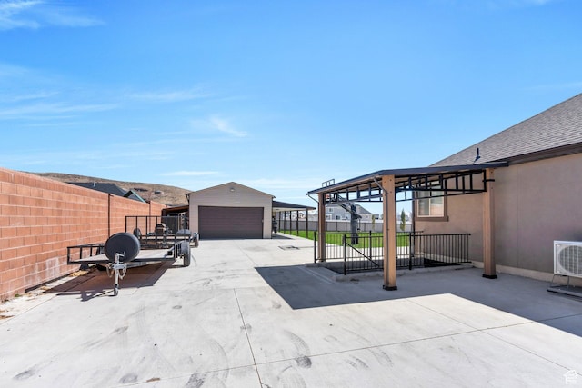 9844 N Faust Station Dr W, Eagle Mountain, UT 84005 - view of patio featuring ac unit, a detached garage, a fenced backyard, and an outdoor structure