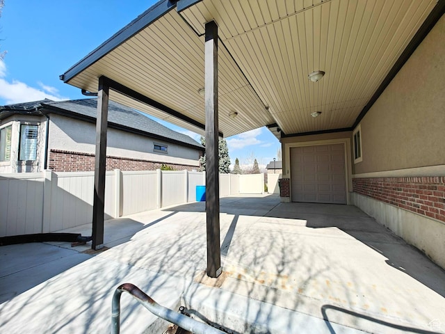 958 S Bridgecreek Ln, Layton, UT 84041 - view of patio featuring fence, driveway, and a garage