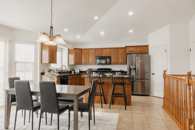 352 S 2000 E, Spanish Fork, UT 84660 - kitchen with vaulted ceiling, a sink, a center island, light tile patterned floors, and black appliances