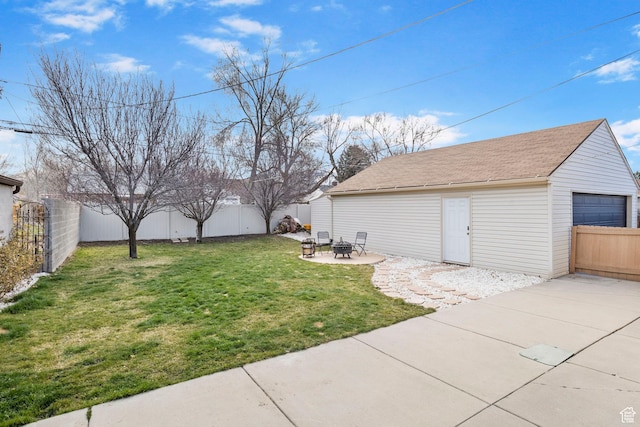 view of yard featuring an outdoor fire pit, a fenced backyard, an outbuilding, and a patio