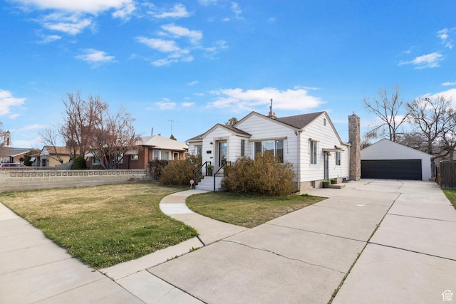 view of front of home featuring an outdoor structure, fence, a detached garage, a front yard, and a chimney