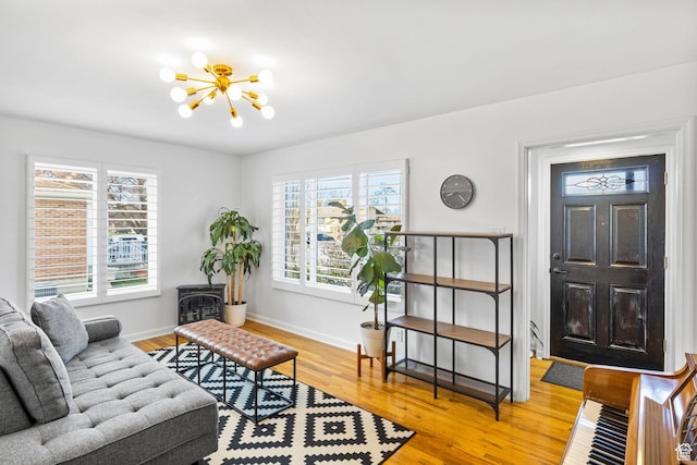 entrance foyer featuring light wood finished floors, baseboards, and a notable chandelier